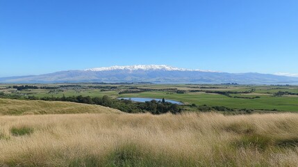 Fototapeta premium Scenic Mountain Range Overlooking Expansive Green Fields