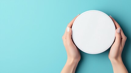 A minimalist image of hands holding a blank plate against a blue background.