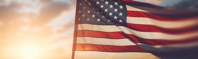 The American flag waves proudly against a backdrop of a stunning sunset, filling the sky with warm hues while illuminating the surrounding landscape.