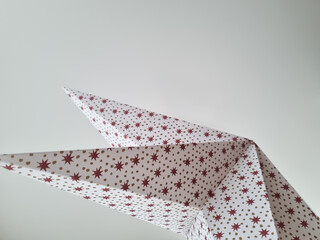 Christmas paper star with a festive pattern. Festive background against the ceiling. Abstract background with a December holiday motive.