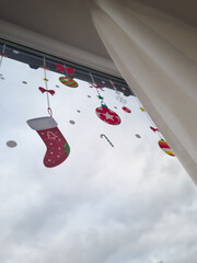 Festive window decoration in anticipation of Christmas. Colorful stickers for windows. Part of a December traditions-making festive atmosphere.
