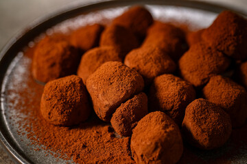 Tasty chocolate truffles powdered with cocoa on table.
Chocolate truffles image.
