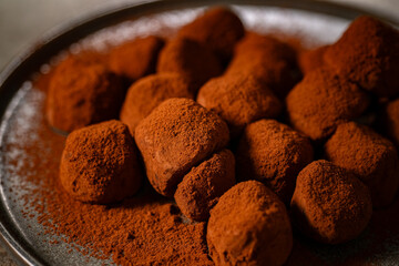 Tasty chocolate truffles powdered with cocoa on table.
Chocolate truffles image.
