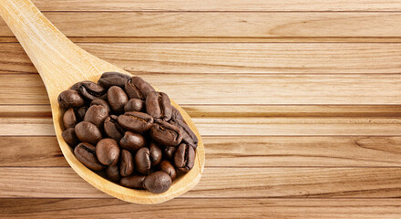 Roasted coffee beans in a wooden spoon on a wooden plank background, ideal for coffee branding, culinary visuals, and rustic designs.