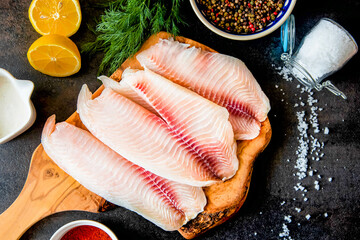 Fresh fish fillet with ingredients for cooking and seasonings on the chopping board
