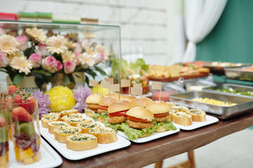 Dining table with various dishes and appetizers n trays serving for banquet