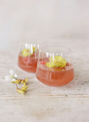 Refreshing spring drink garnished with edible flowers in elegant glassware on wooden table