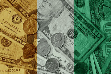 colourful flag of ivory coast on a dollar money banknotes and coins background. finance concept. macro shot