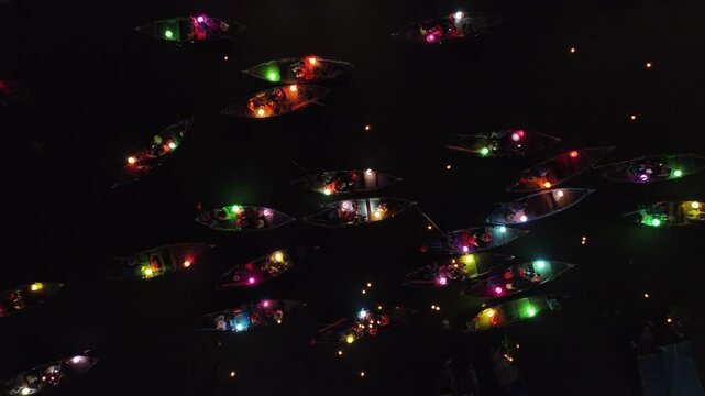 Aerial view of colorful lanterns illuminating the Thu Bon River with boats floating peacefully, Hoi An, Vietnam.
