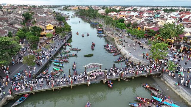Aerial view of thu bon river with colorful boats and a bustling crowd, Hoi An, Vietnam.