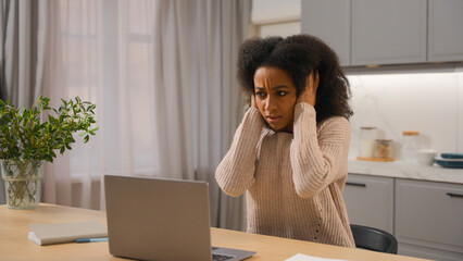 Annoyed angry woman African American businesswoman freelancer online working laptop at home kitchen...