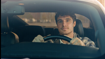 Happy Caucasian man car driver steering wheel enjoy travel trip drive modern electric automobile in...