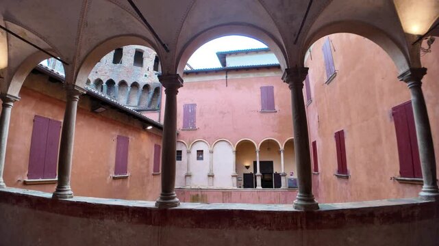 Featuring the courtyard of Dozza castle, showcasing arches, columns, and a medieval tower in the charming village of Dozza, Emilia Romagna, Italy
