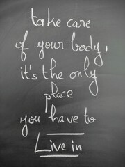 Motivational handwritten quote on a chalkboard encouraging self-care and health - take care of your...