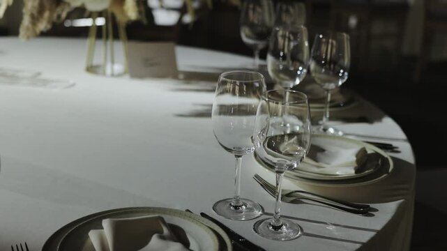 Elegant wedding reception with beautifully arranged tables and wine glasses decor