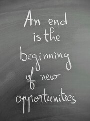 Inspiring handwritten quote on chalkboard about endings leading to new opportunities - an end is a beginning of new opportunities