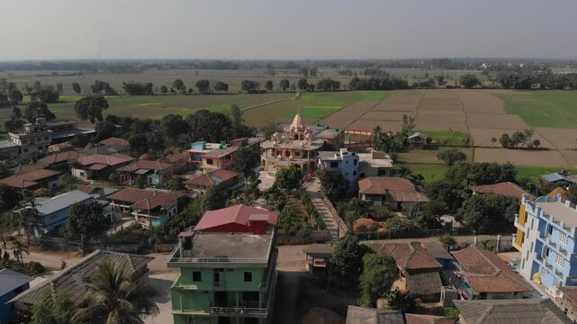 Aerial shot of Radha Krishna Temple in the middle of the Village and big plain fields in the background, Terai Nepal