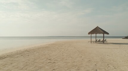 Fototapeta premium Secluded beach hut with lounge chairs on tranquil sandy shore.