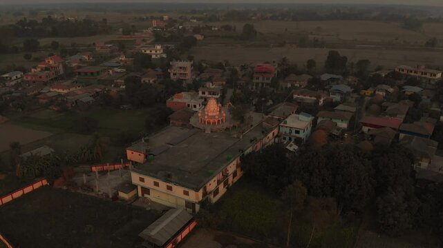 Aerial shot of Radha Krishna Temple in the middle of the Village and big plain fields in the background, Terai Nepal