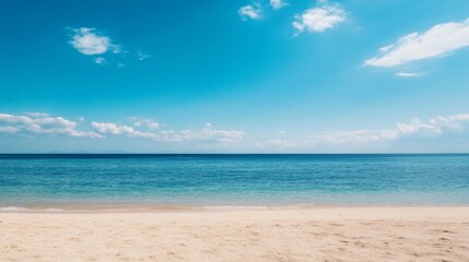 Fototapeta premium Serene beach scene with clear blue sky and calm ocean.