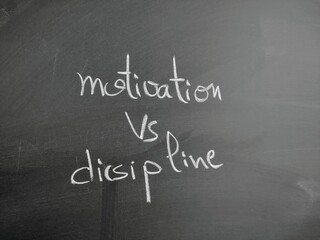 Motivation Versus Discipline Written in Chalk on a Blackboard Surface