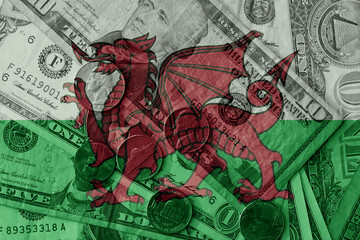 Fototapeta premium colourful flag of wales on a dollar money banknotes and coins background. finance concept. macro shot