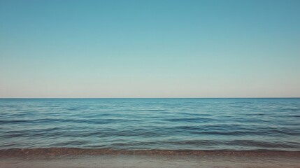 Fototapeta premium Calm ocean meeting tranquil sky, blurred horizon.