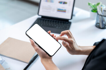 A woman is holding a cell phone and looking at it