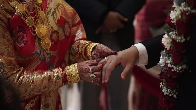 Bride Placing a Ring on Her Groom's Finger in a Traditional Hindu Wedding Ceremony