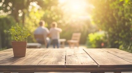 Fototapeta premium Two people relaxing in the background of an empty wooden table with a small potted plant on a sunny day