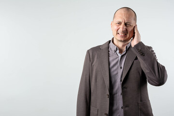 Man with earache, ear pain on gray background