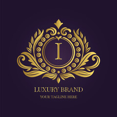 Gold Letter 'I' Logo with Ornamental Patterns and Floral Motifs on Purple  
