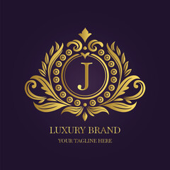Gold Letter 'J' Logo with Ornamental Patterns and Floral Motifs on Purple  
