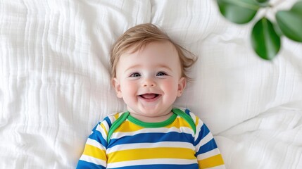Happy baby on white bedding, plant in background; ideal for parenting websites
