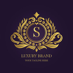 Gold Letter 'S' Logo with Ornamental Patterns and Floral Motifs on Purple  

