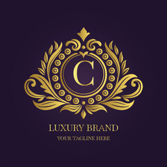 Gold Letter 'C' Logo with Ornamental Patterns and Floral Motifs on Purple  
