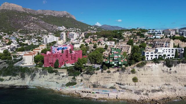 Aerial view of la muralla roja and coastal buildings by the vibrant mediterranean sea, calpe, spain.