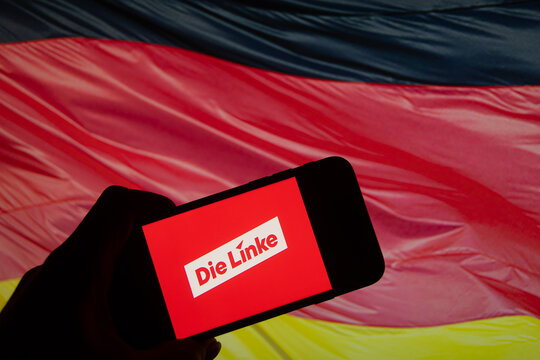 Rheinbach, Germany  26 January 2025,  The logo of the German party "Die Linke" on the display of a smartphone in front of a Germany flag (focus on the logo)
