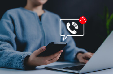 Phone scam alert notification concept. A person holding a smartphone with a digital scam warning...