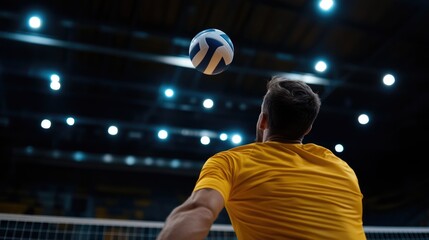 Volleyball player serves, indoor arena, night game, spotlights