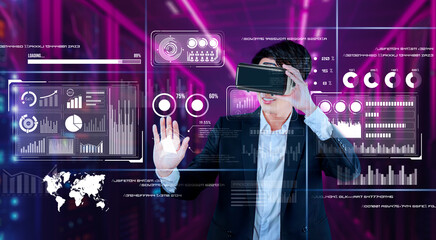 Businessman with headset standing at data center while analyzing financial data. Manager pointing marketing statistic hologram and using augmented reality goggles while making a decision. Ingenuity.