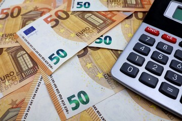 Money notes of 50 euros and a calculator in close-up. Selective focus. Financial concept.