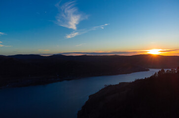 Aerial view of a river between hills seen in the evening at sunset