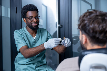Fototapeta premium Male stomatologist with patient during dental visit before implanting teeth