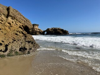 View of Laguna Beach coastline in Southern California with natural rock arch in the background