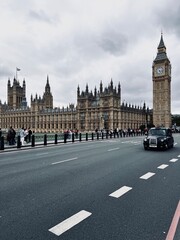 Fototapeta premium View of Westminster Bridge, Parliament, and Big Ben with a classic black London taxi in the foreground. Iconic British scene, perfect for projects on tourism, landmarks, and cityscapes.