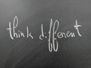 Fototapeta premium Think differently to inspire creativity and innovation, showcased by handwritten text on a chalkboard.