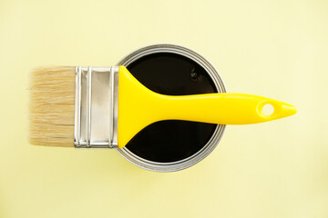 Paint brush with black paint on yellow background