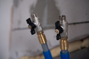 Detailed view of plumbing valves and hoses in a home installation project