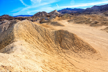 A desert landscape with a large hill in the background